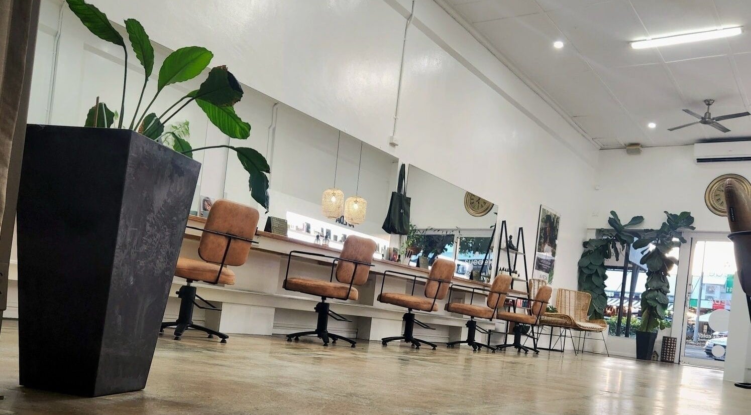 Elegant interior of Suede Hair Skin Body in Cairns City, Queensland, AU, showcasing stylish salon chairs and greenery.