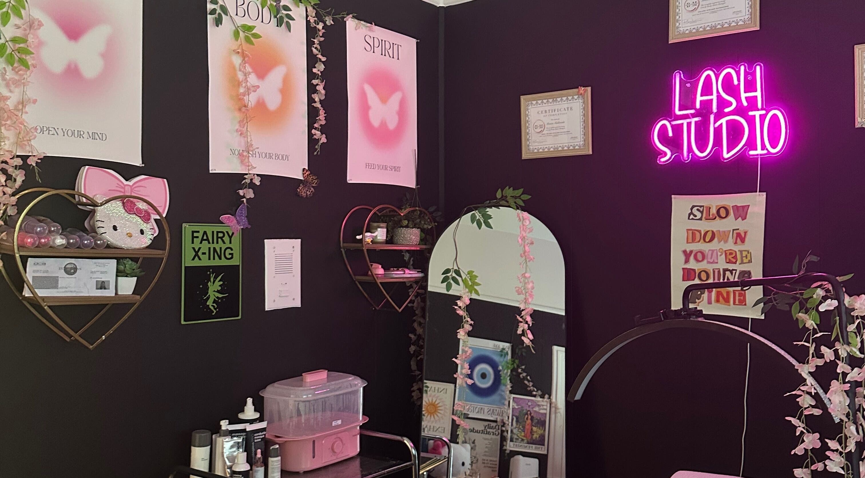 Cozy interior of Talkaboutlashes in Fresno, California with neon sign and floral decor.