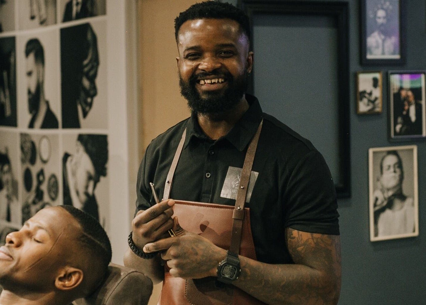 Barber smiling with client at The Art of Man, Pretoria, Gauteng, ZA, showcasing professional grooming services.