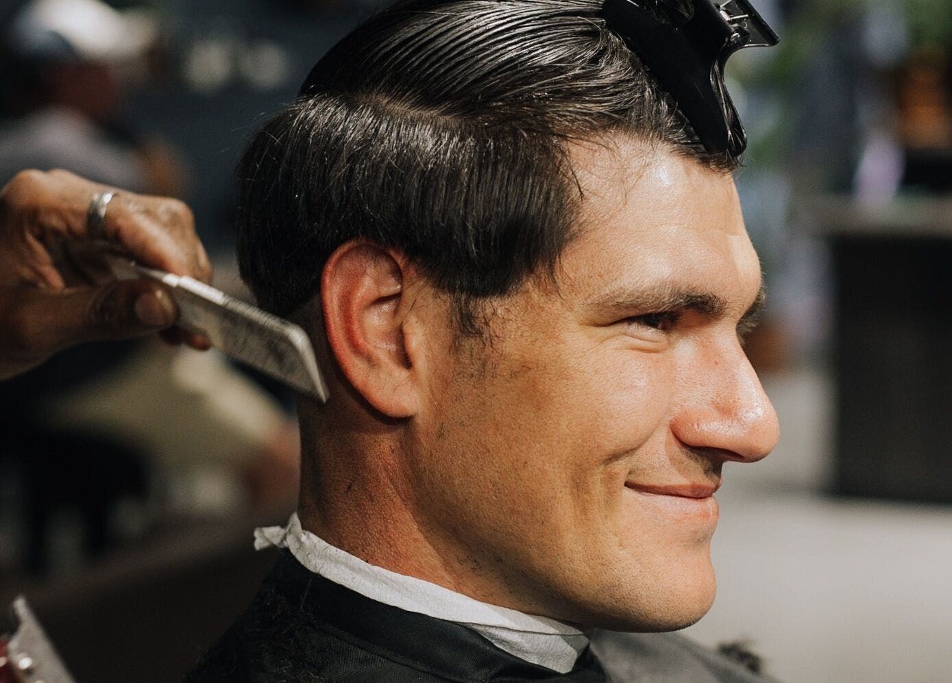 Professional haircutting at The Art of Man in Pretoria, Gauteng, ZA. Barber styling a happy client.