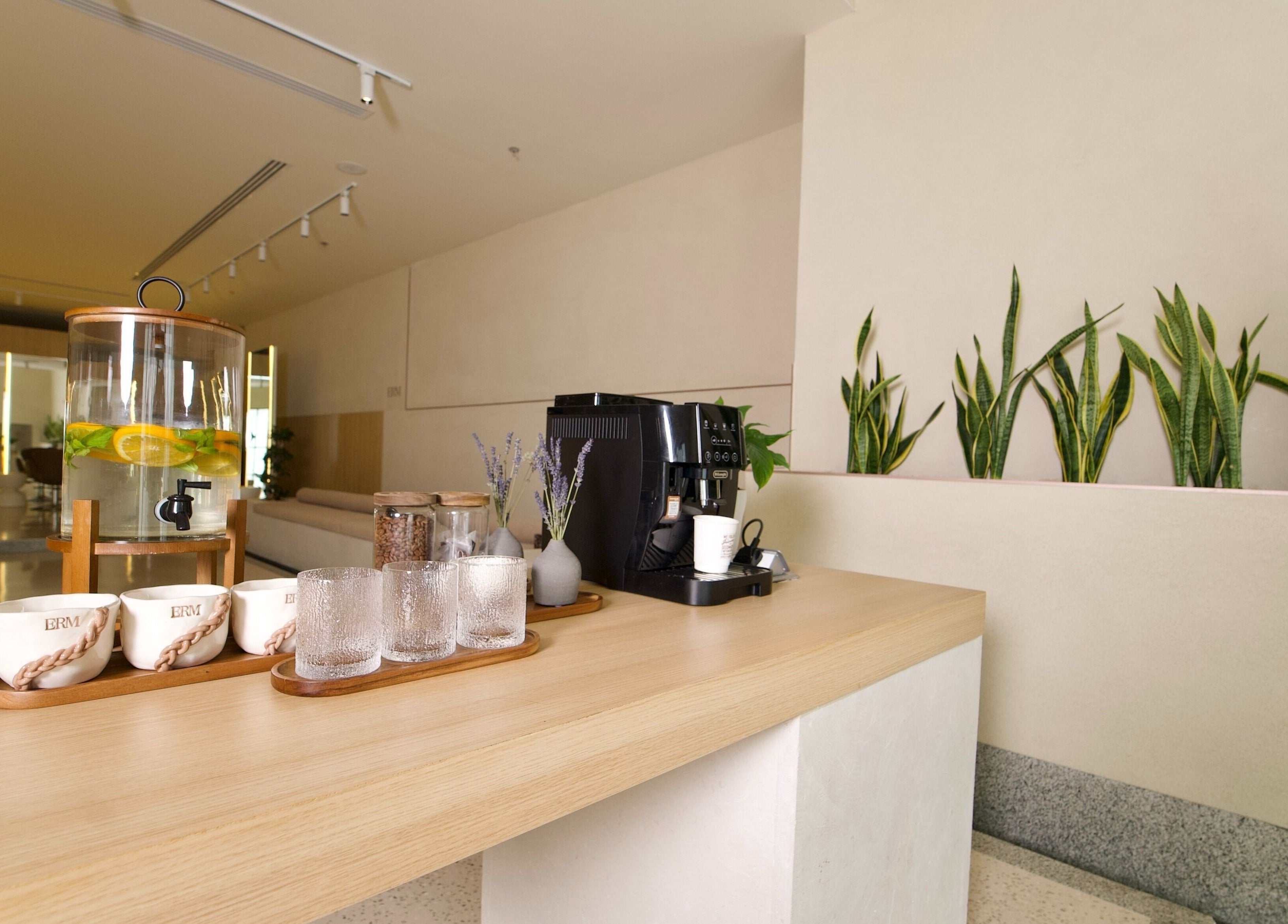 منظر لمقهى هادئ في ERM Hair Spa، الخبر، المنطقة الشرقية، المملكة السعودية يظهر محطة قهوة حديثة ونباتات.