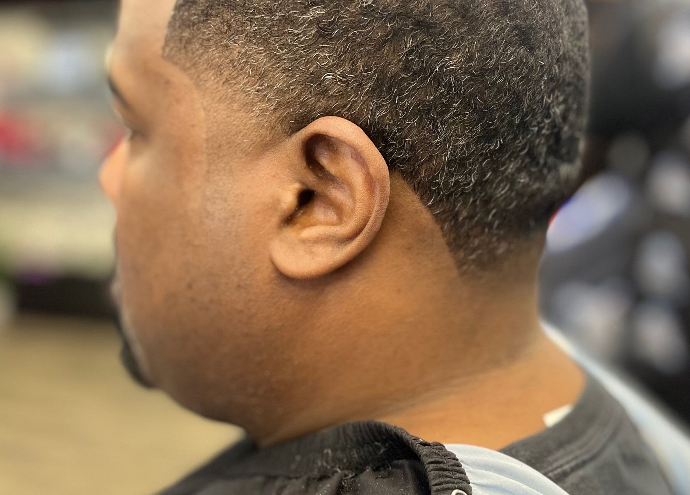 Man receiving a haircut at Den Of Sauce, Lathrup, Michigan, US showcasing clean lines.