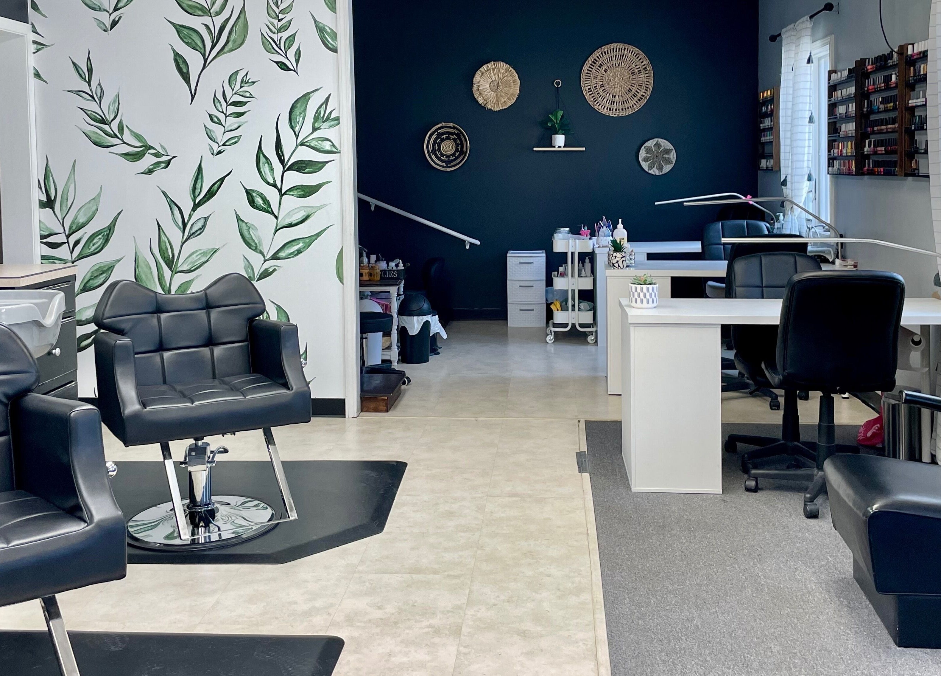 Elegant interior of Emily Beck Esthetics at The Upper Cut in Bryan, Ohio, US with chic black chairs and greenery.
