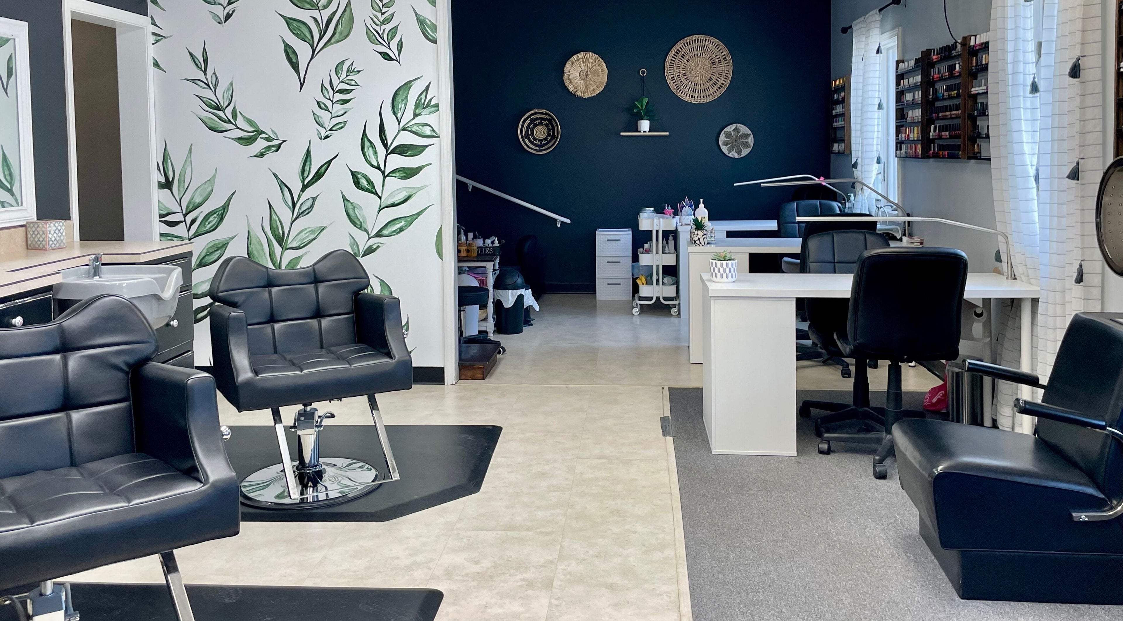 Elegant interior of Emily Beck Esthetics at The Upper Cut in Bryan, Ohio, US with chic black chairs and greenery.