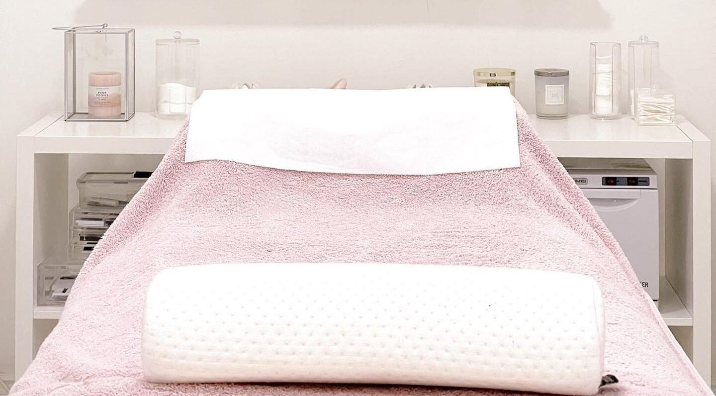 Cozy treatment bed with plush pink towel at Privé Salon | Bournemouth in Bournemouth, England, GB.