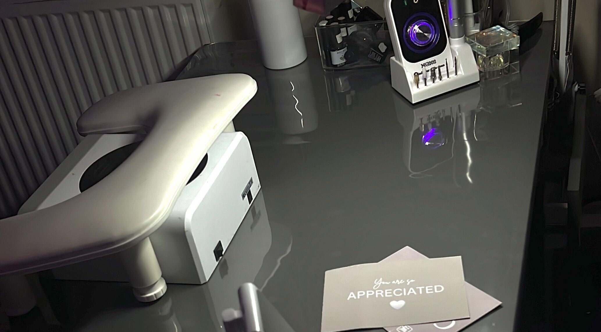 Sleek nail station at Nailzbycharl, Swansea, Wales, GB showcasing modern nail care tools and appreciation card.