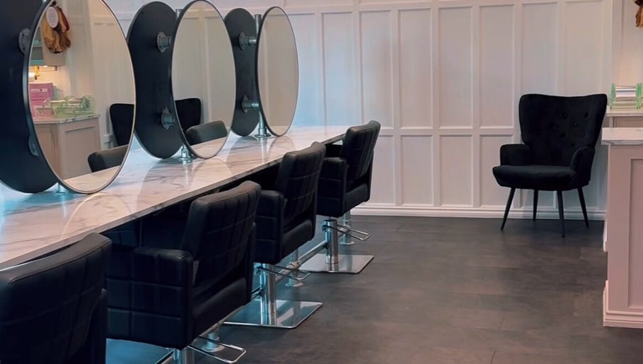 Chic salon interior at Crowned Hair by Emily, Carlisle, England, GB with modern styling stations and sleek decor.