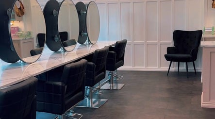 Chic salon interior at Crowned Hair by Emily, Carlisle, England, GB with modern styling stations and sleek decor.