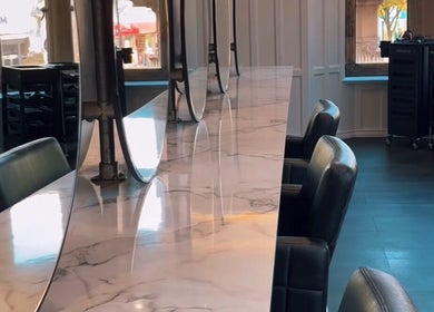 Sleek salon interior of Crowned Hair by Emily, Carlisle, England, GB with chic marble countertops.