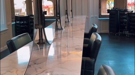 Sleek salon interior of Crowned Hair by Emily, Carlisle, England, GB with chic marble countertops.