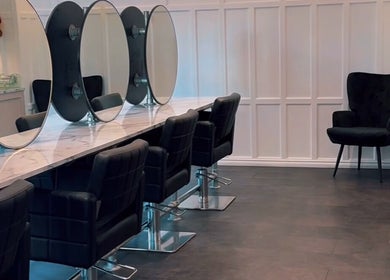 Elegant interior of Crowned Hair by Emily in Carlisle, England, GB featuring modern salon chairs and mirrors.