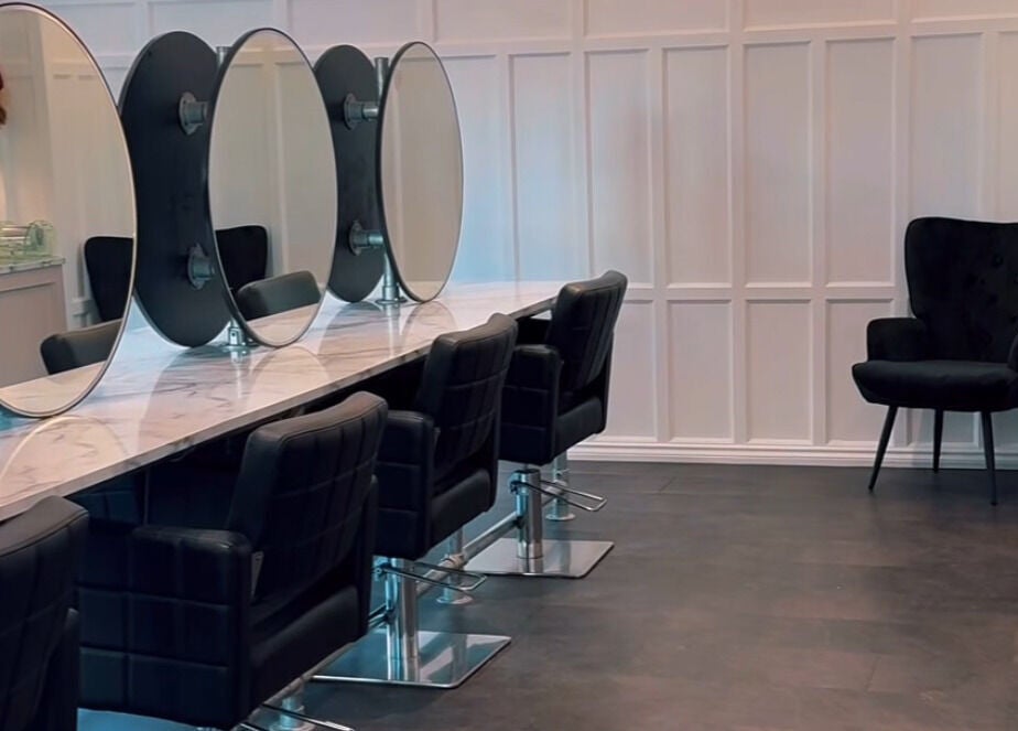 Modern salon interior at Crowned Hair by Emily, Carlisle, England, GB, featuring chic styling chairs and mirrors.