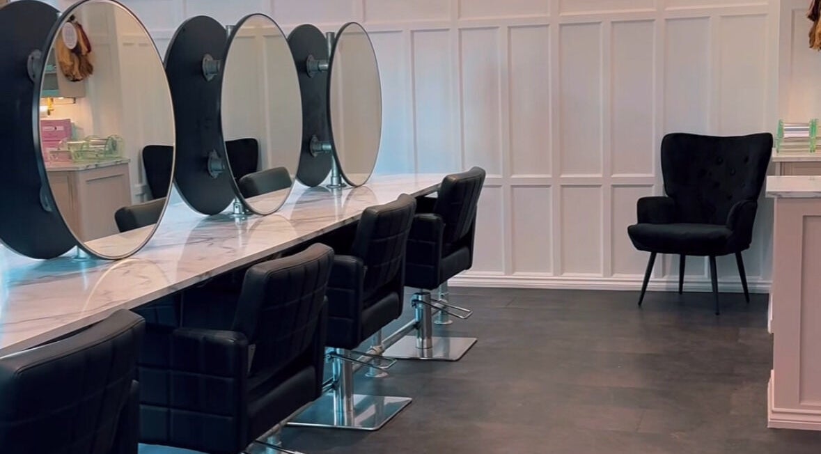 Modern salon interior at Crowned Hair by Emily, Carlisle, England, GB, featuring chic styling chairs and mirrors.