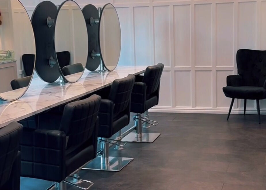 Elegant salon interior at Crowned Hair by Emily in Carlisle, England, GB with stylish chairs and mirrors.
