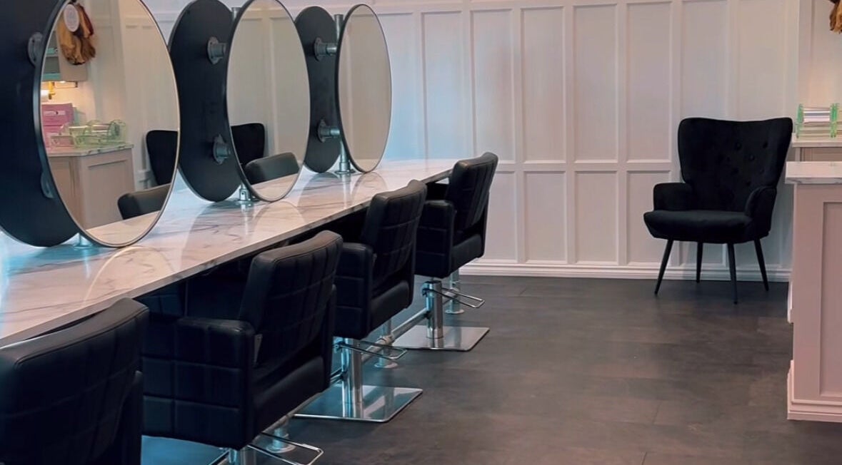 Elegant salon interior at Crowned Hair by Emily in Carlisle, England, GB with stylish chairs and mirrors.