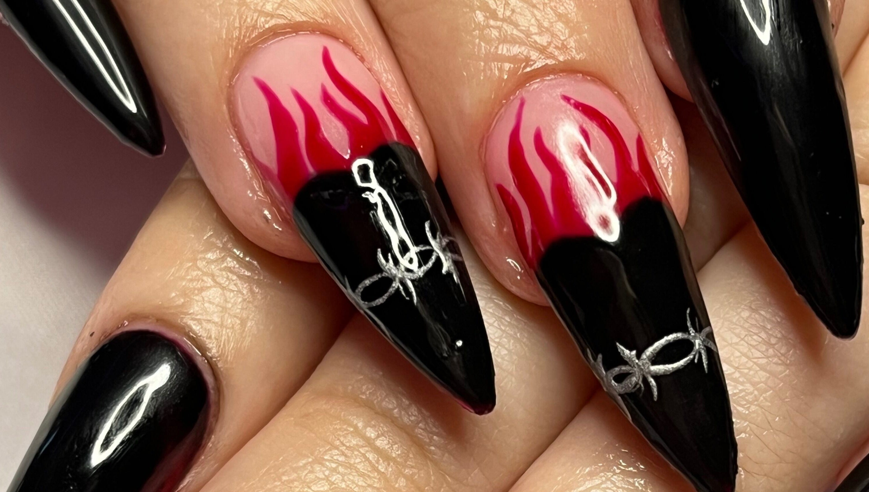 Bold flame nail art at Banríon Beauty by April in Dublin, IE showcases intricate black and red designs.