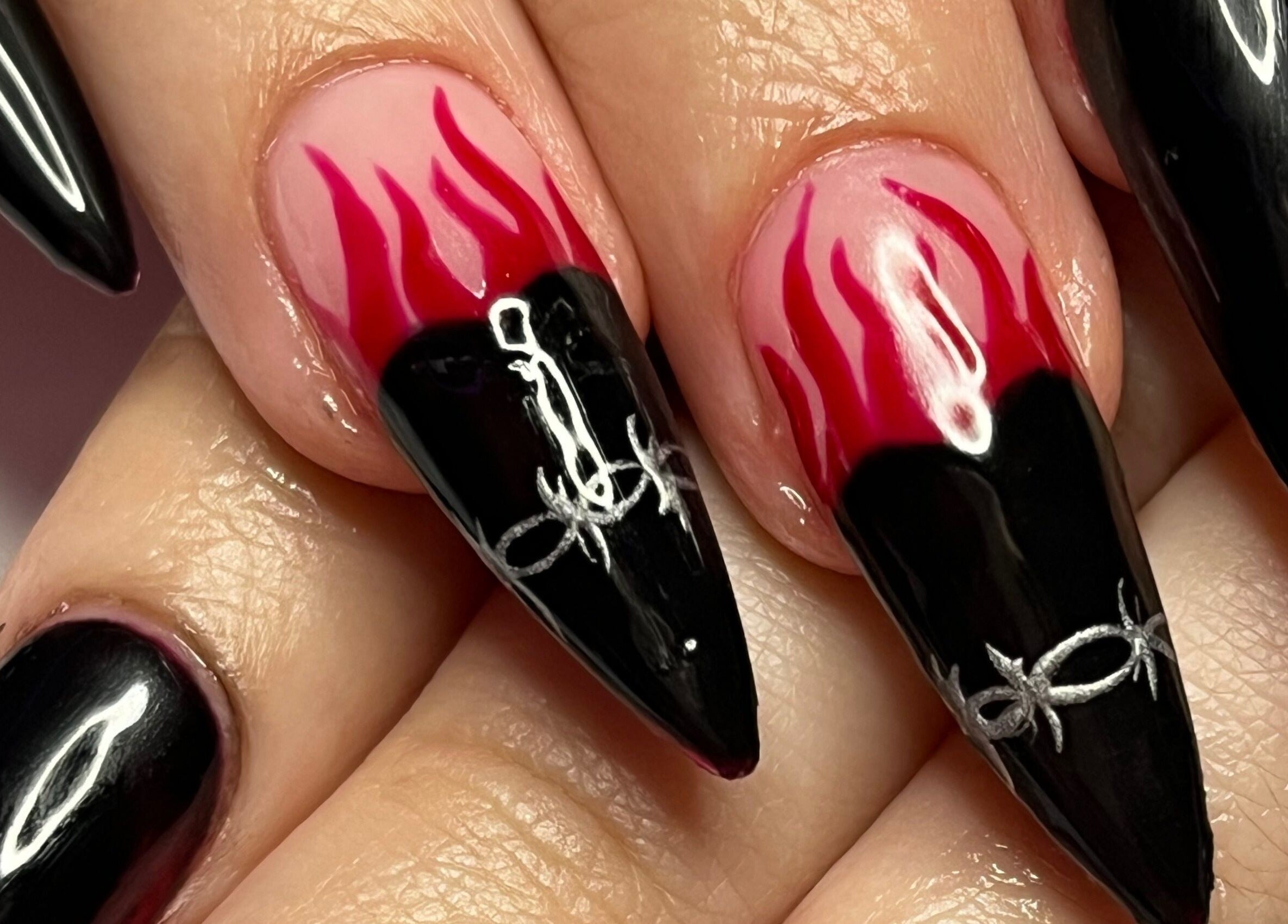 Bold flame nail art at Banríon Beauty by April in Dublin, IE showcases intricate black and red designs.
