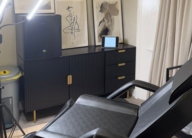 Modern treatment room at Kaesthetics London, England, GB showcasing a sleek chair and ambient decor.