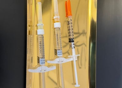 Kaesthetics London syringes for cosmetic treatments in London, England, GB displayed against a gold background.