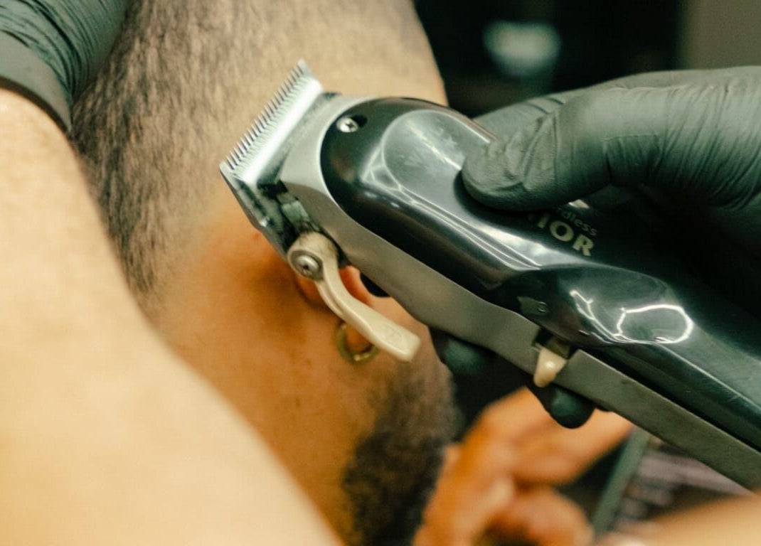 Expert barber at GB Studio & Hairsupplies, Kralendijk, Bonaire, ensures a precise haircut with electric clippers.