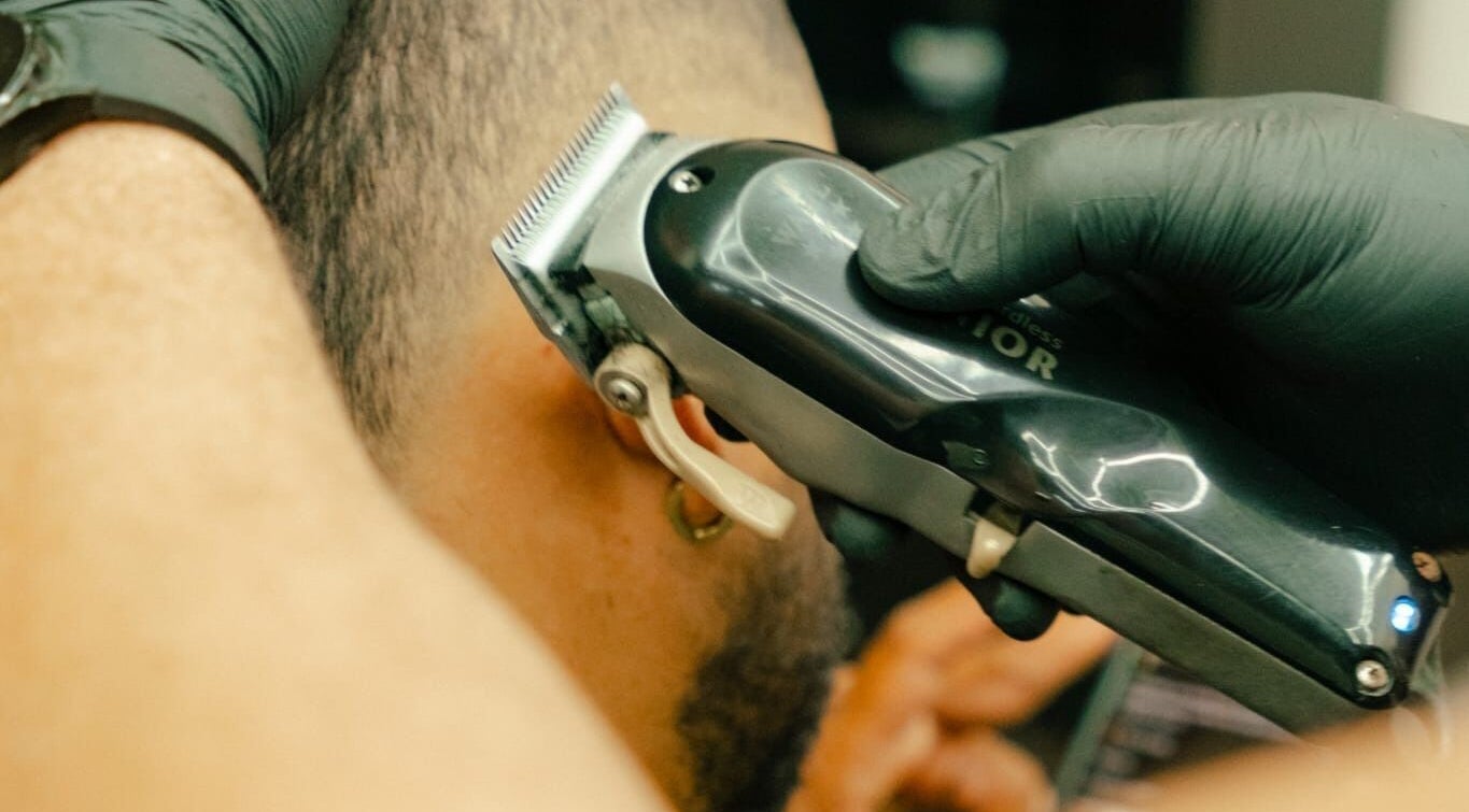 Expert barber at GB Studio & Hairsupplies, Kralendijk, Bonaire, ensures a precise haircut with electric clippers.