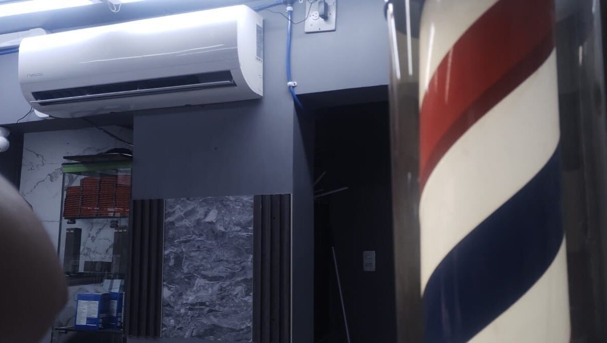 Interior de LEGENDARY BARBER 91 en Medellín, Antioquia, CO, con icónica barra de barbero en espiral.