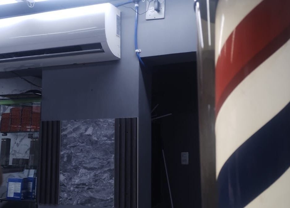 Interior de LEGENDARY BARBER 91 en Medellín, Antioquia, CO, con icónica barra de barbero en espiral.