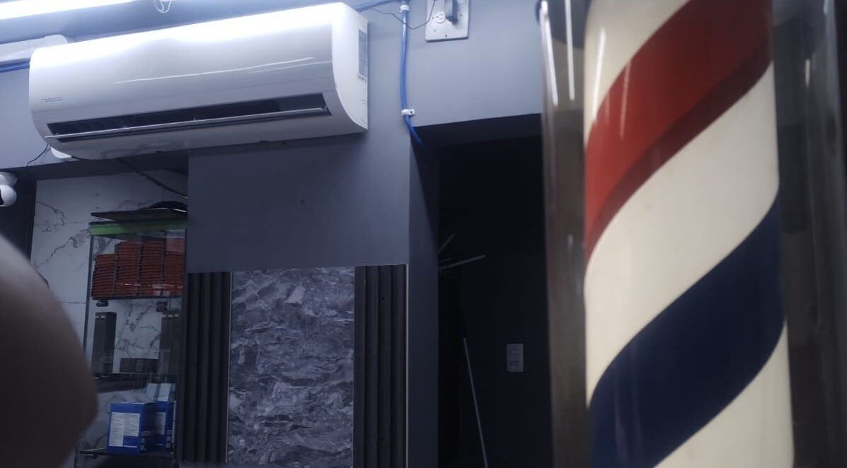 Interior de LEGENDARY BARBER 91 en Medellín, Antioquia, CO, con icónica barra de barbero en espiral.