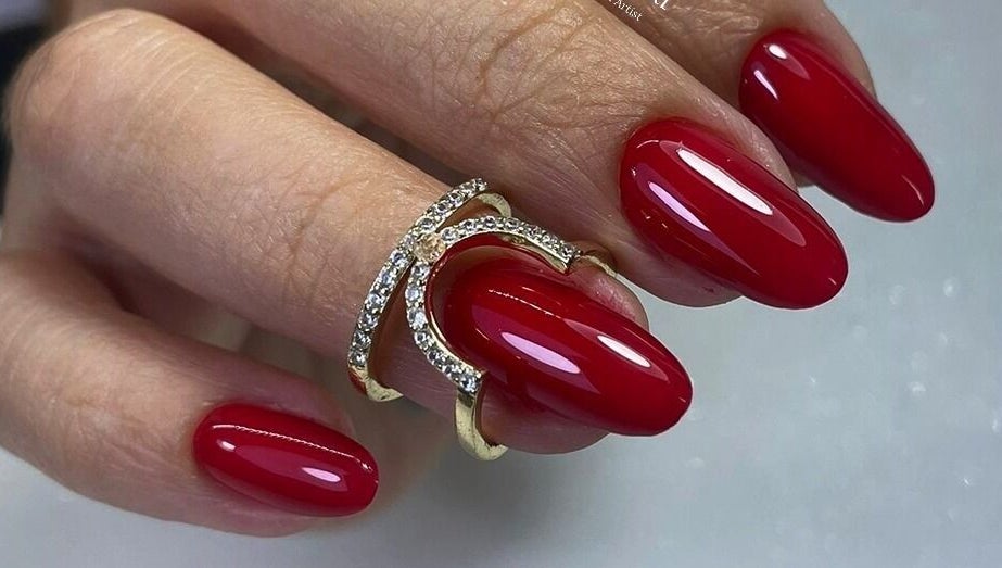 Manicura roja brillante en Mely Nail Art, La Habana, La Habana, CU, con elegante anillo dorado.