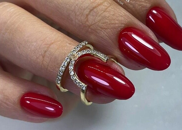 Manicura roja brillante en Mely Nail Art, La Habana, La Habana, CU, con elegante anillo dorado.