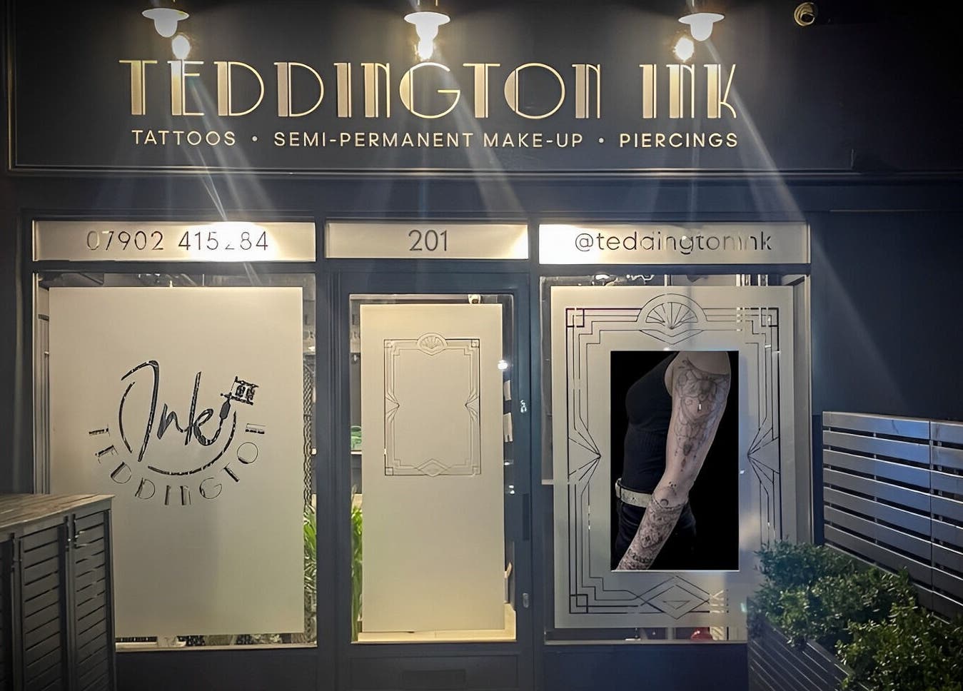 Teddington Ink's illuminated storefront in Teddington, England, GB showcasing tattoos and body art.