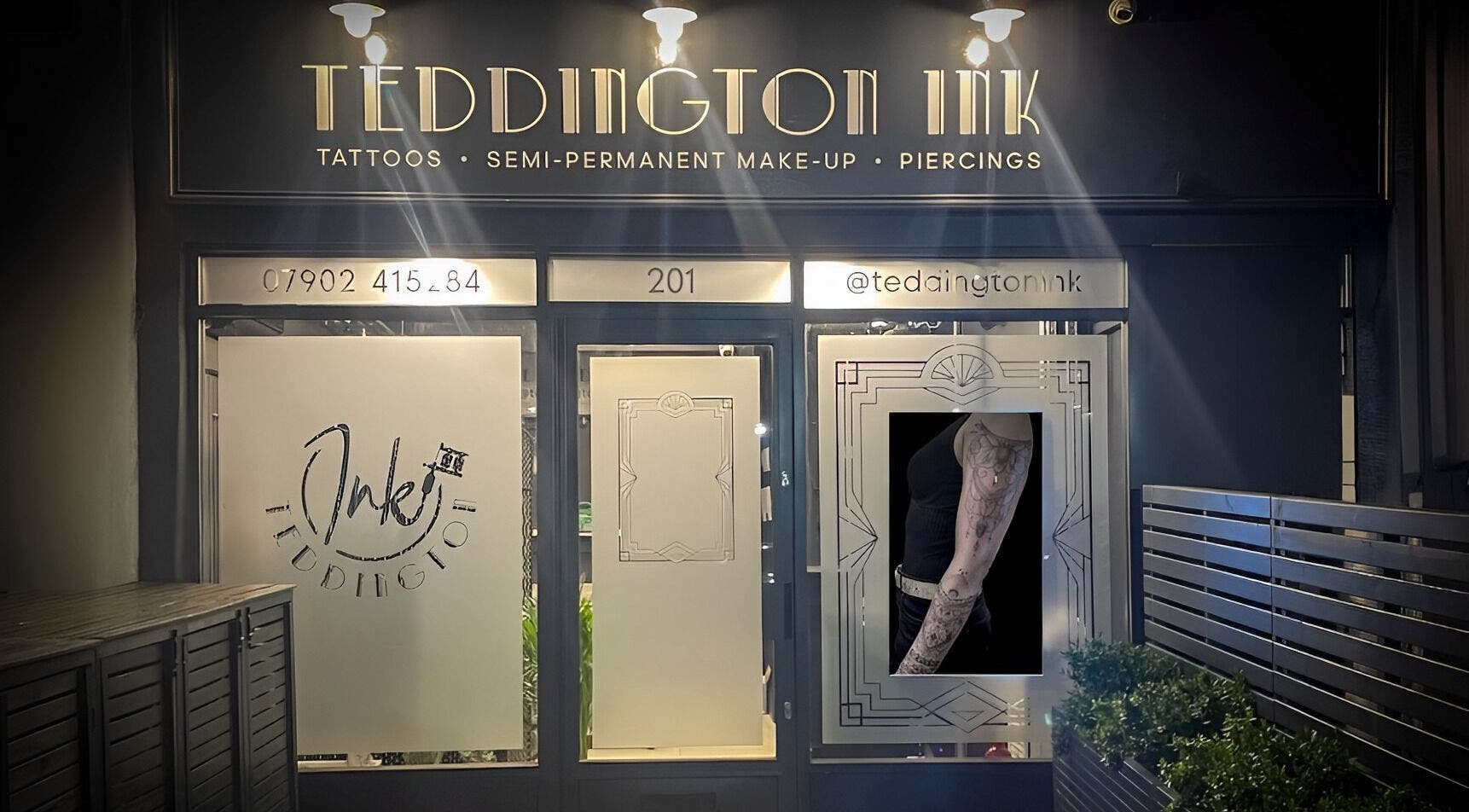 Teddington Ink's illuminated storefront in Teddington, England, GB showcasing tattoos and body art.