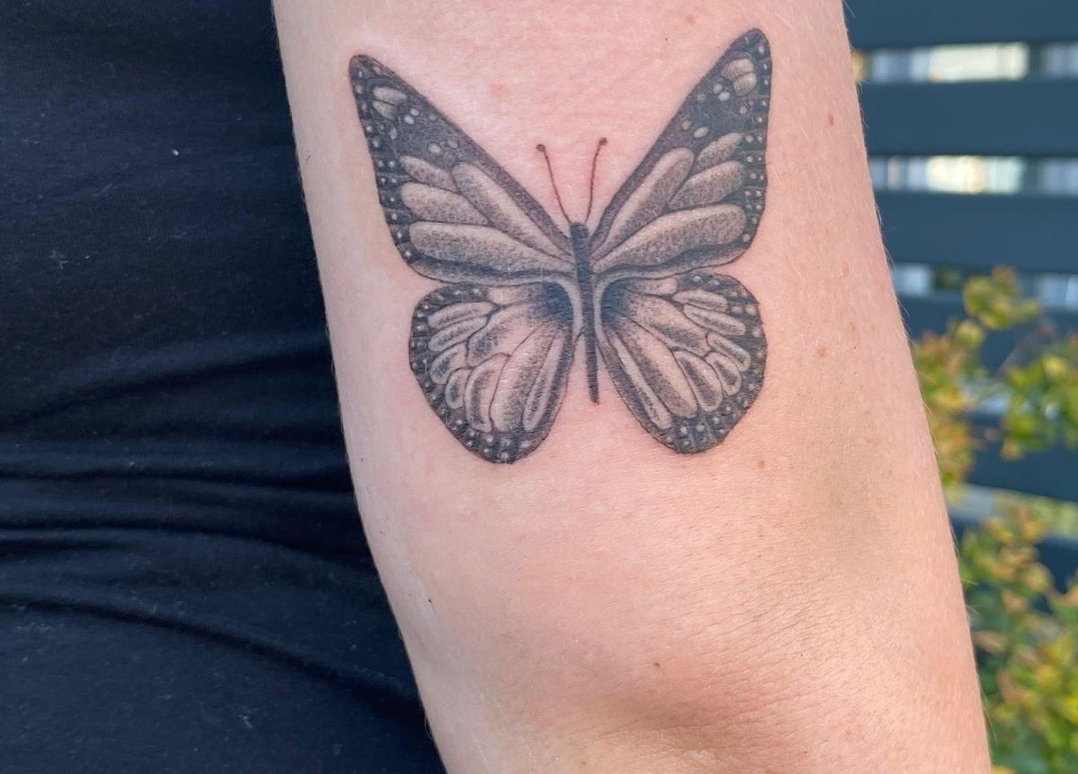Delicate butterfly tattoo on arm at Teddington Ink, Teddington, England, GB.