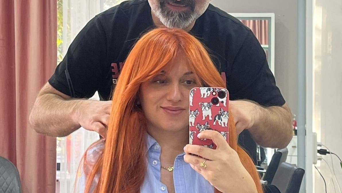 Woman with vibrant haircut at Vm.HairWorks Signature, Yerevan, Yerevan, AM, captures selfie with stylist.