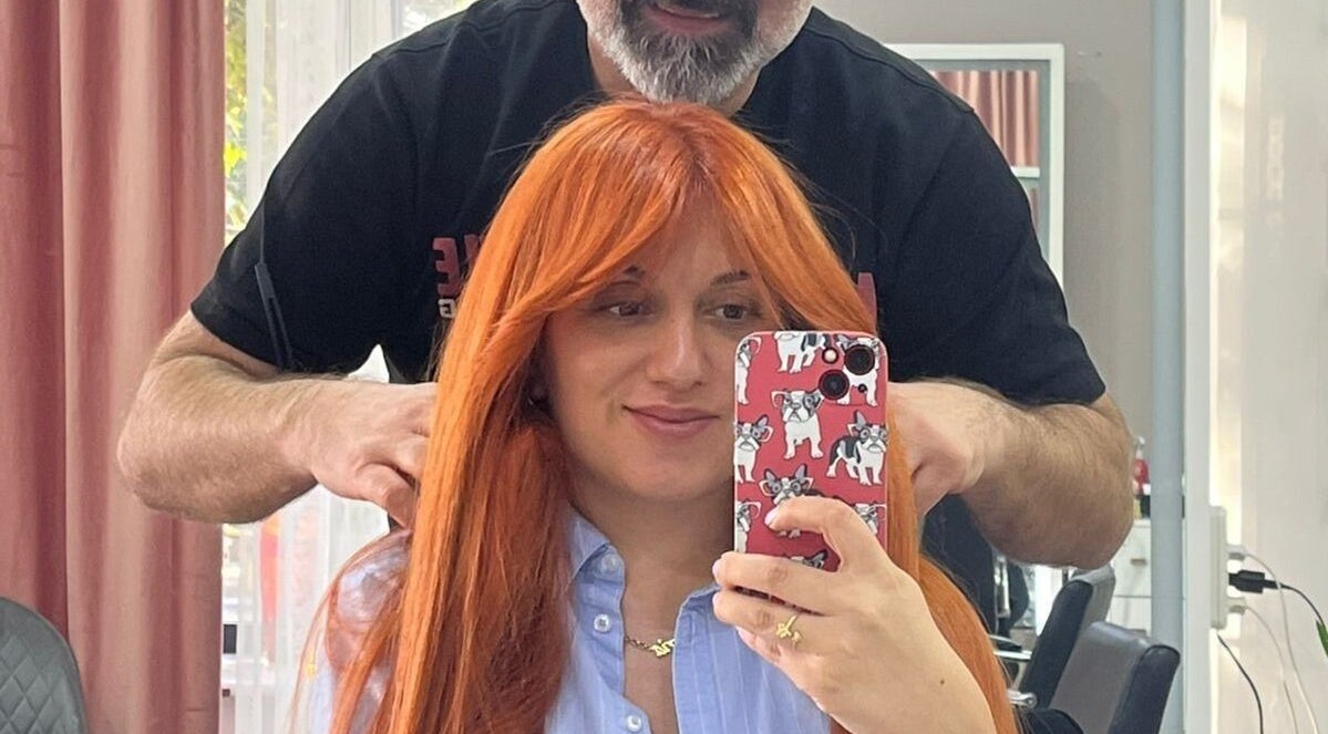 Woman with vibrant haircut at Vm.HairWorks Signature, Yerevan, Yerevan, AM, captures selfie with stylist.