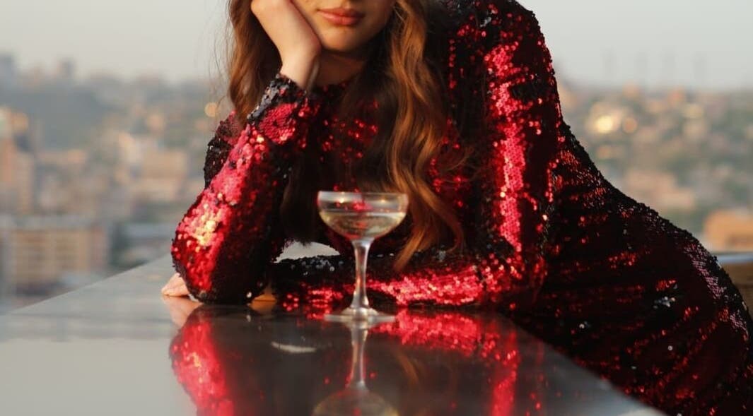 Glamorous woman in sequin dress at Vm.HairWorks Signature, Yerevan, Yerevan, AM, enjoying city view.