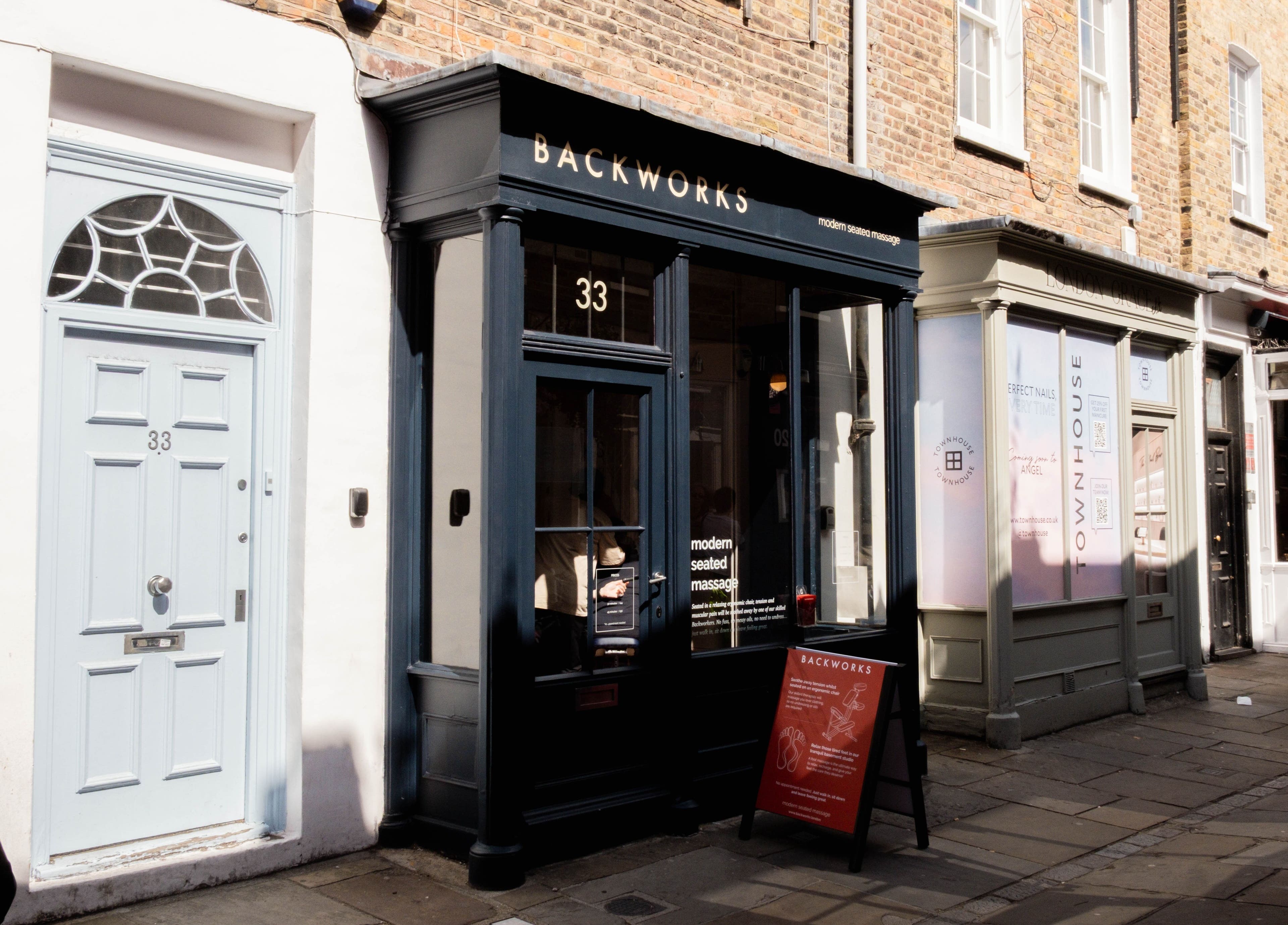Exterior of Backworks wellness venue in London, GB, showcasing its inviting facade on a sunny street.