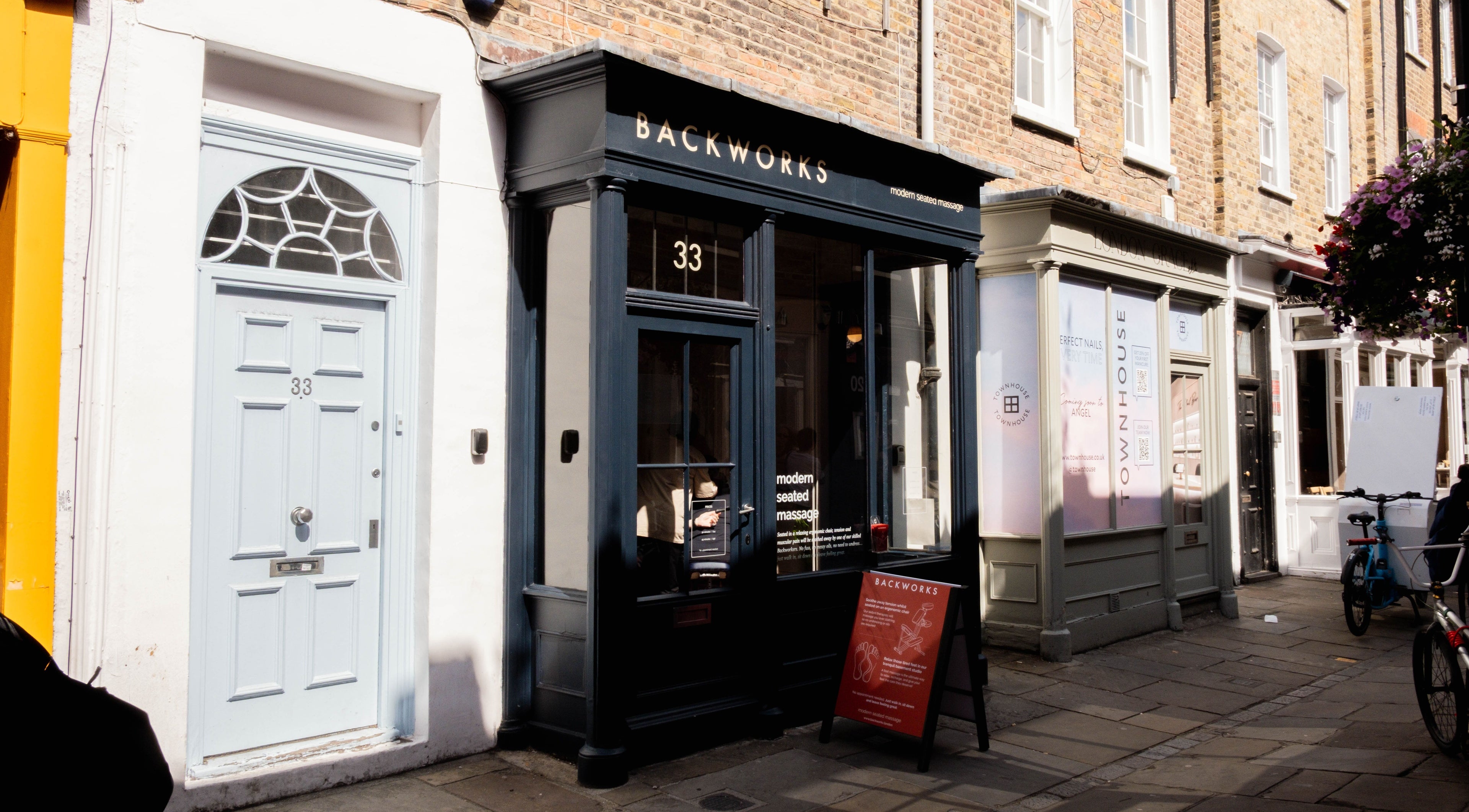 Exterior of Backworks wellness venue in London, GB, showcasing its inviting facade on a sunny street.