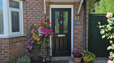 Charming entrance at Wellbeing with Jaydene at Jaydene’s Home, York, England, GB, framed by vibrant flowers.
