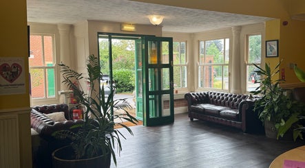 Elegant entrance at Wellbeing with Jaydene, Redmayne Lodge in Strensall, England, GB with leather sofas and plants.