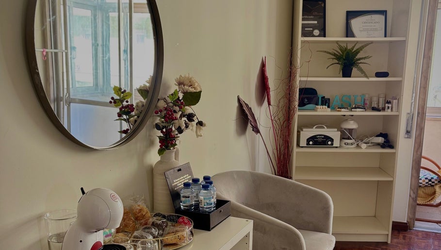 Cozy corner at Giovana Victoria Lash Studio, Lisboa, Lisboa, PT with mirror decor and refreshments.