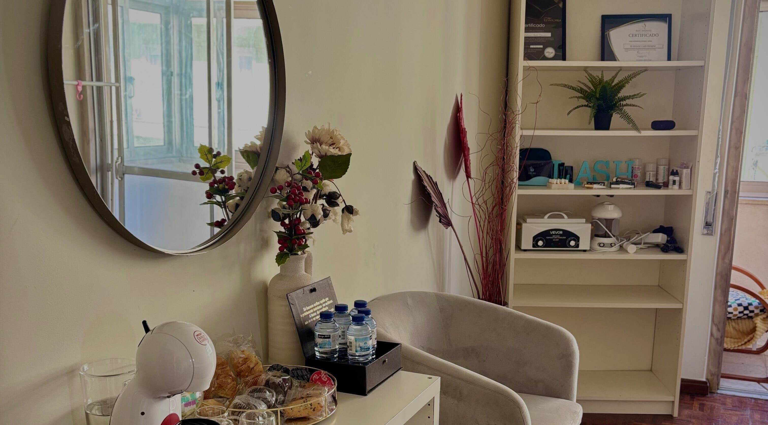 Cozy corner at Giovana Victoria Lash Studio, Lisboa, Lisboa, PT with mirror decor and refreshments.