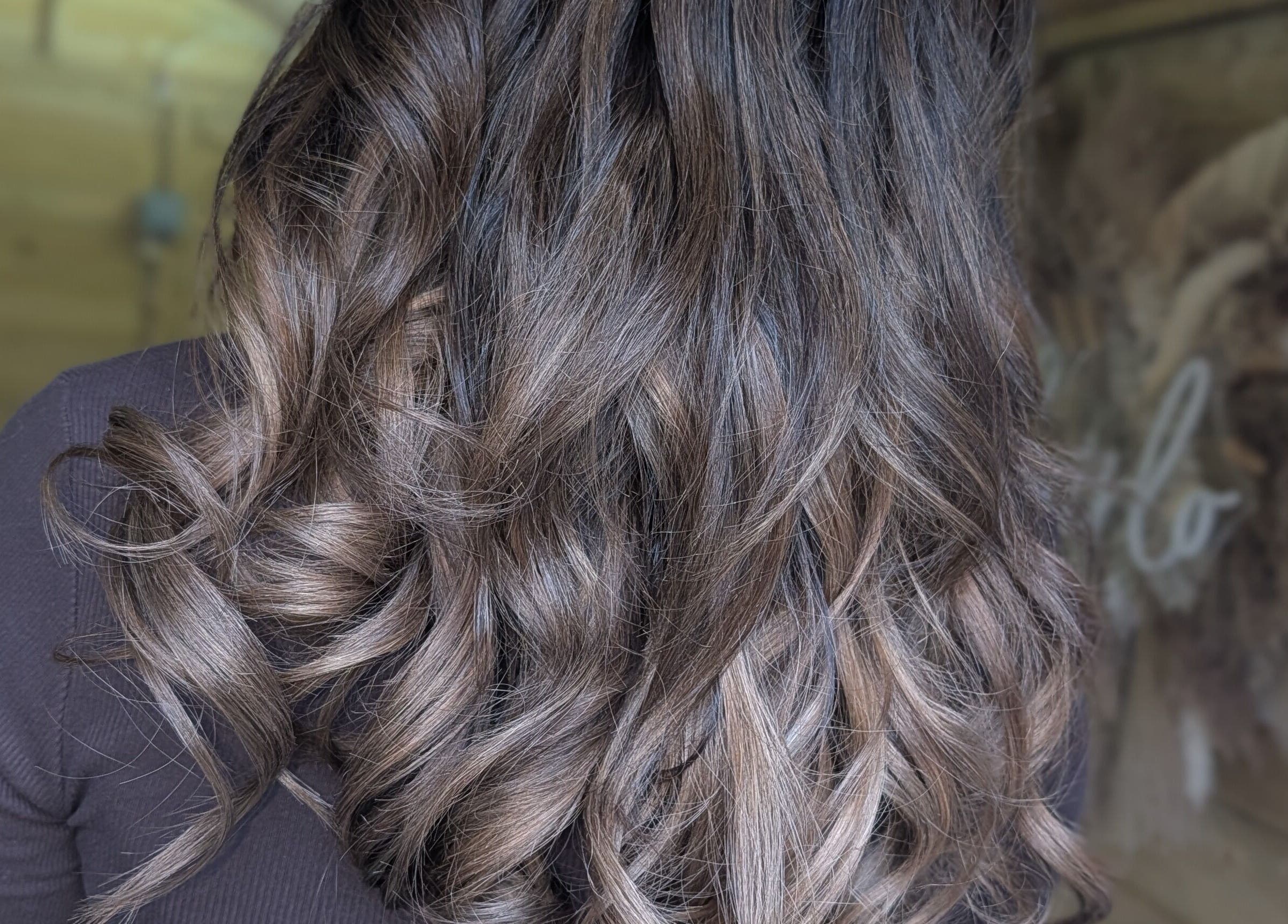 Stylish wavy hair at Hairlo salon in Swinton, England, GB showcasing glossy brown curls.