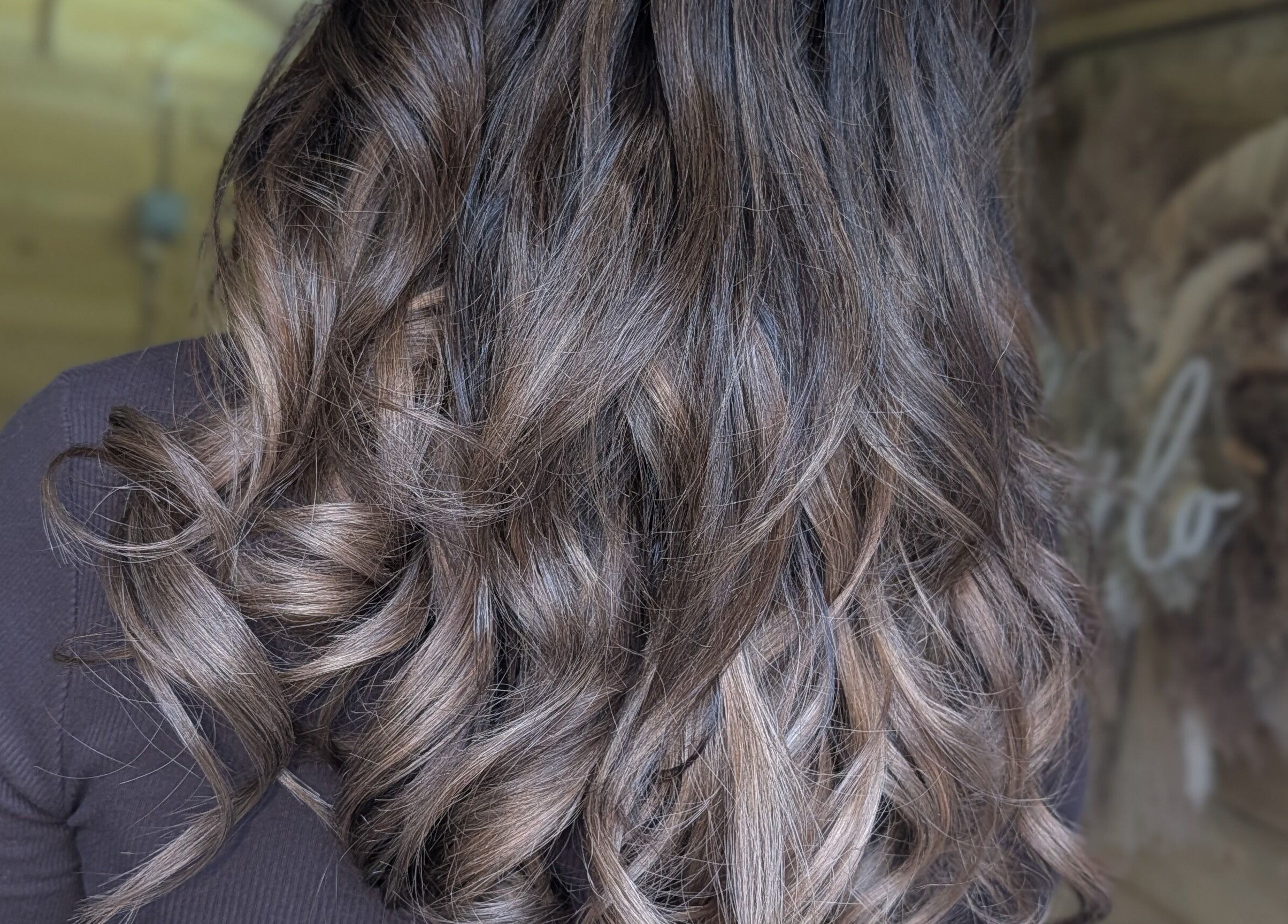 Stylish wavy hair at Hairlo salon in Swinton, England, GB showcasing glossy brown curls.