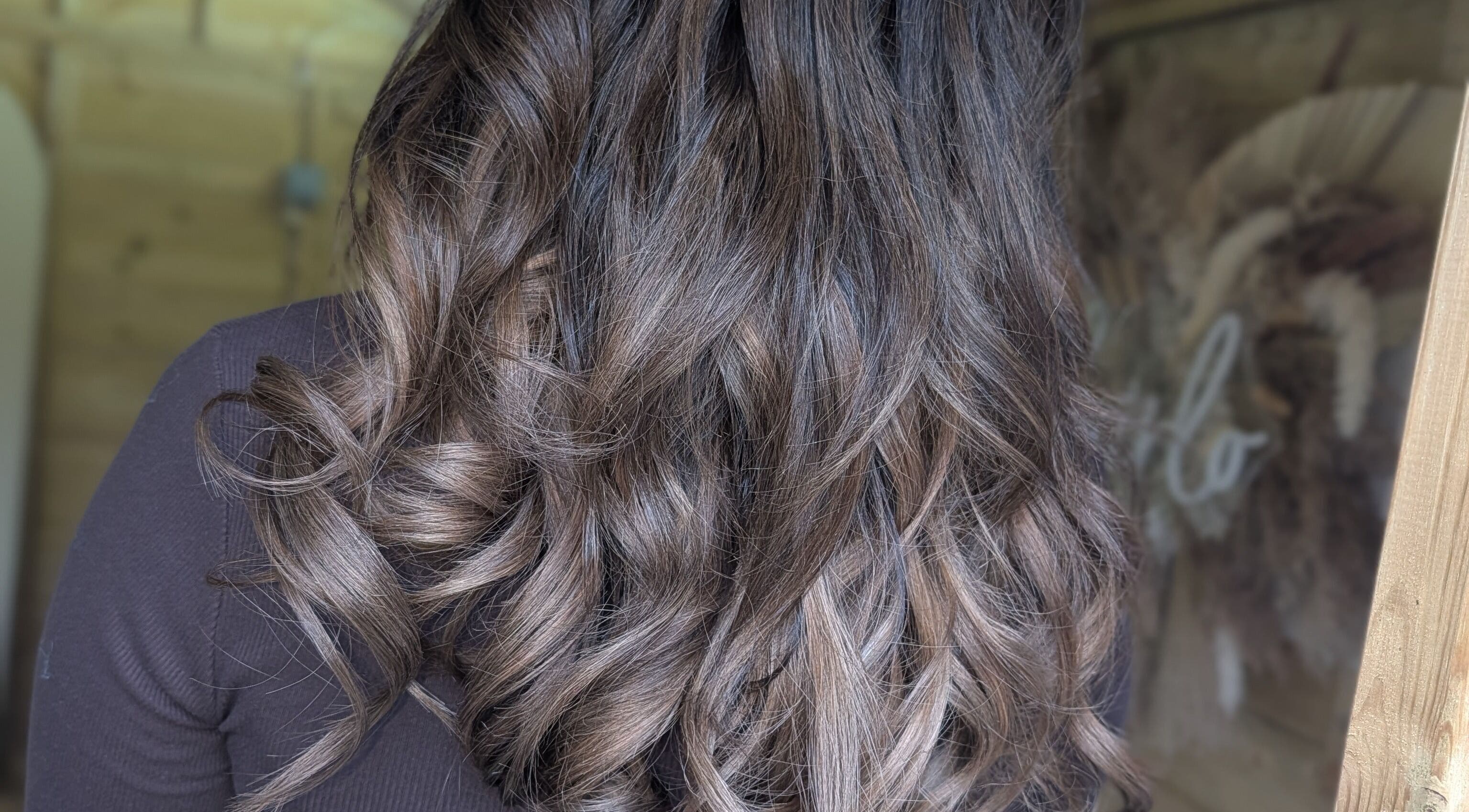 Stylish wavy hair at Hairlo salon in Swinton, England, GB showcasing glossy brown curls.