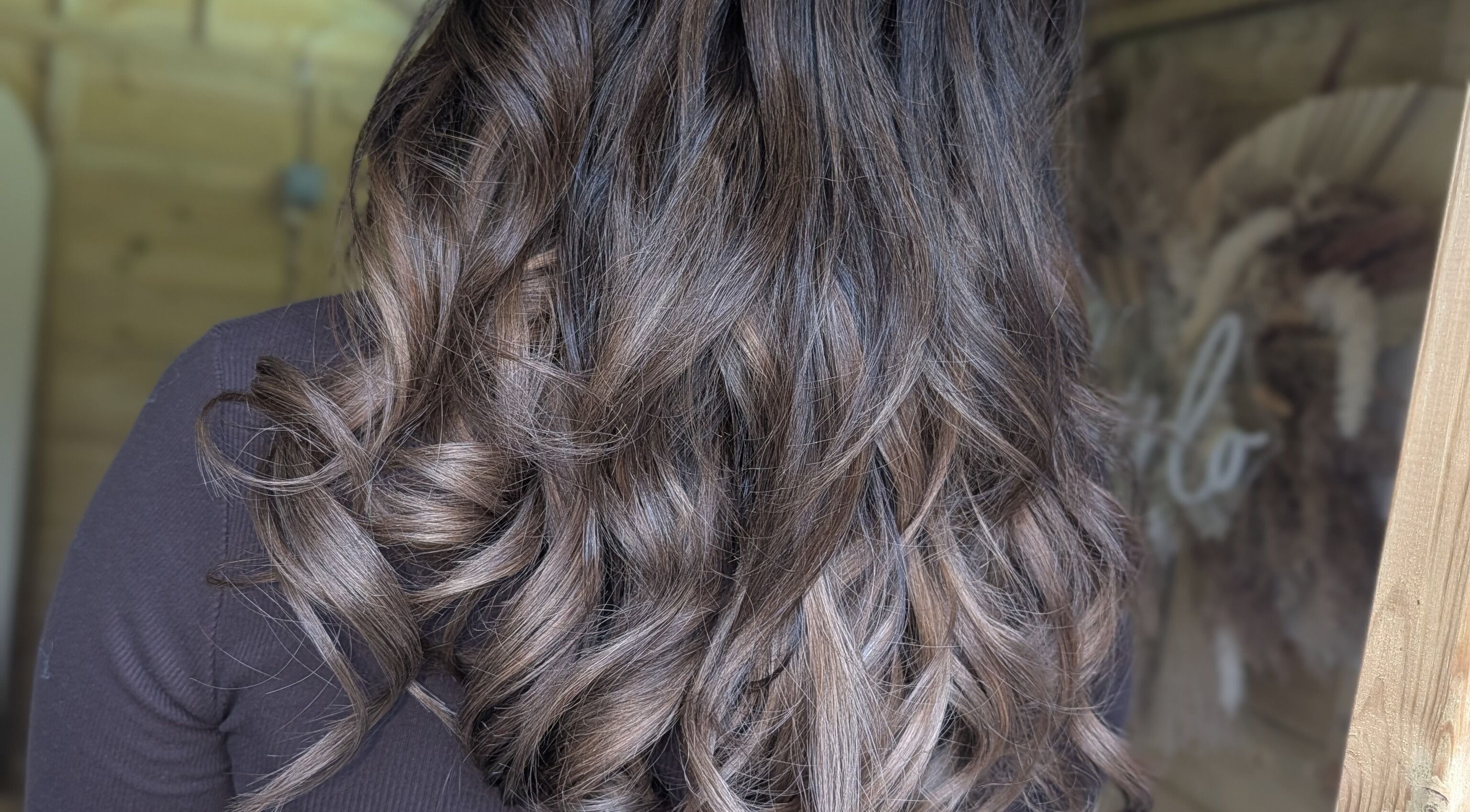 Stylish wavy hair at Hairlo salon in Swinton, England, GB showcasing glossy brown curls.
