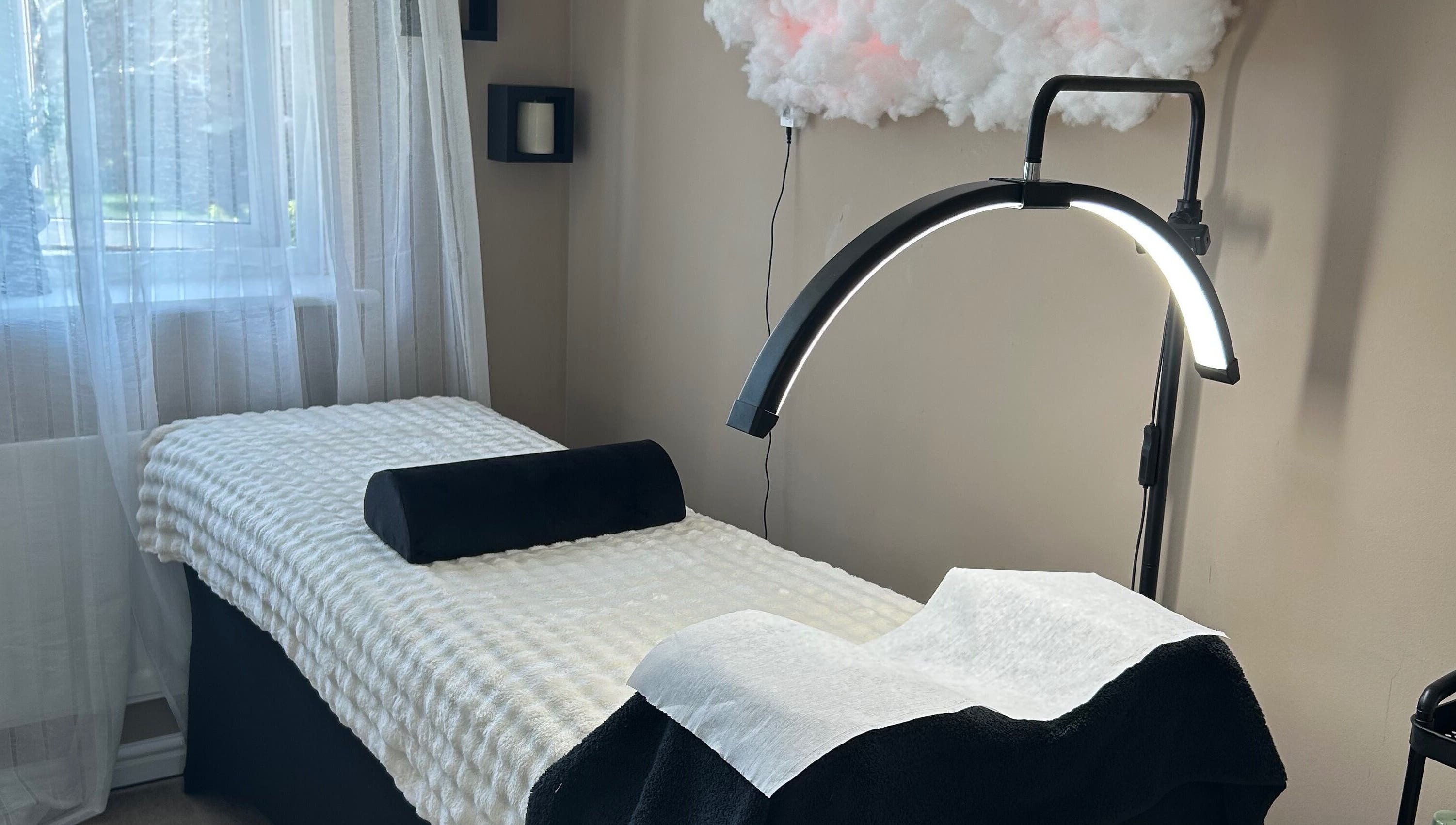 Tranquil treatment room at By Jade, Biggleswade, England, GB with therapy bed and modern lighting.