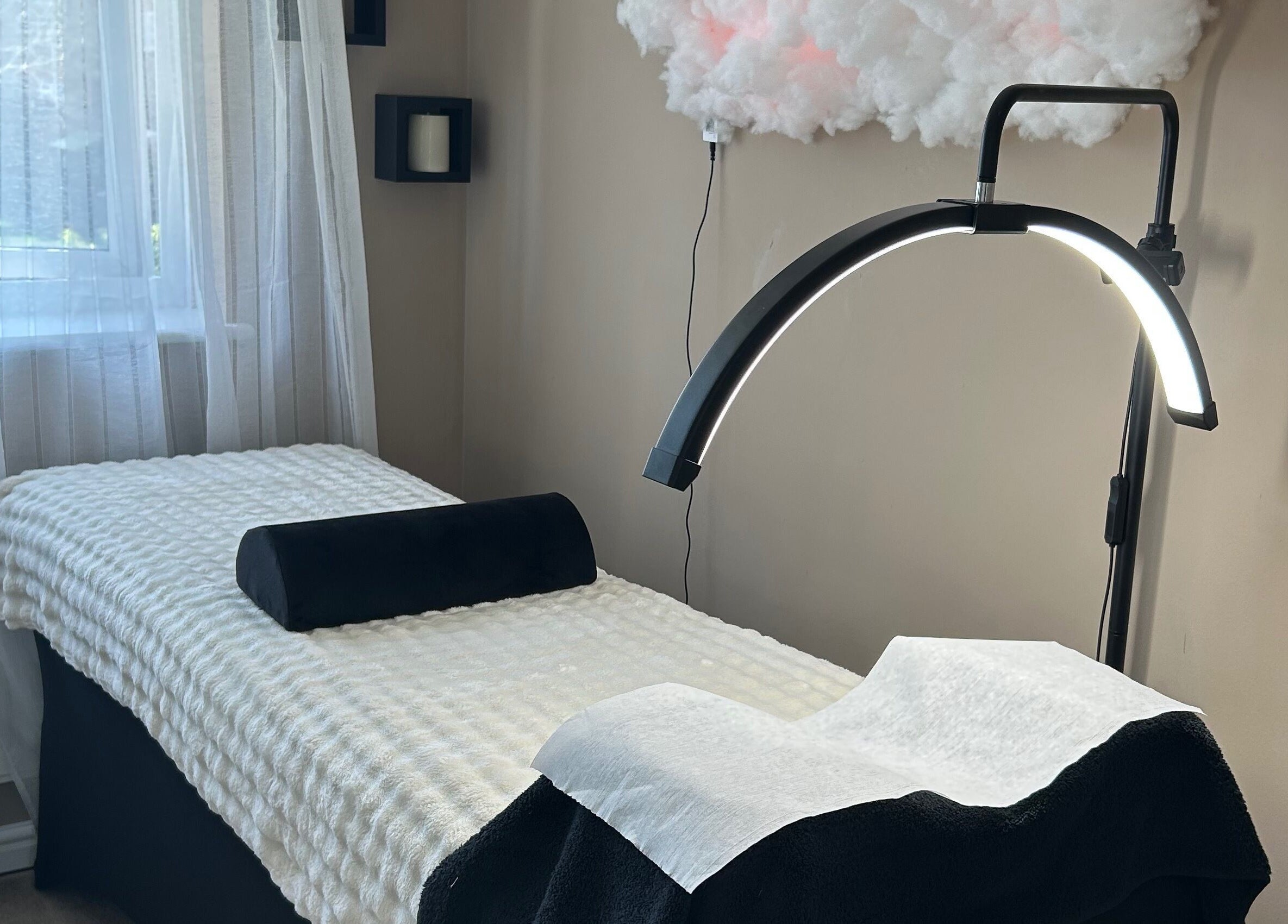 Tranquil treatment room at By Jade, Biggleswade, England, GB with therapy bed and modern lighting.