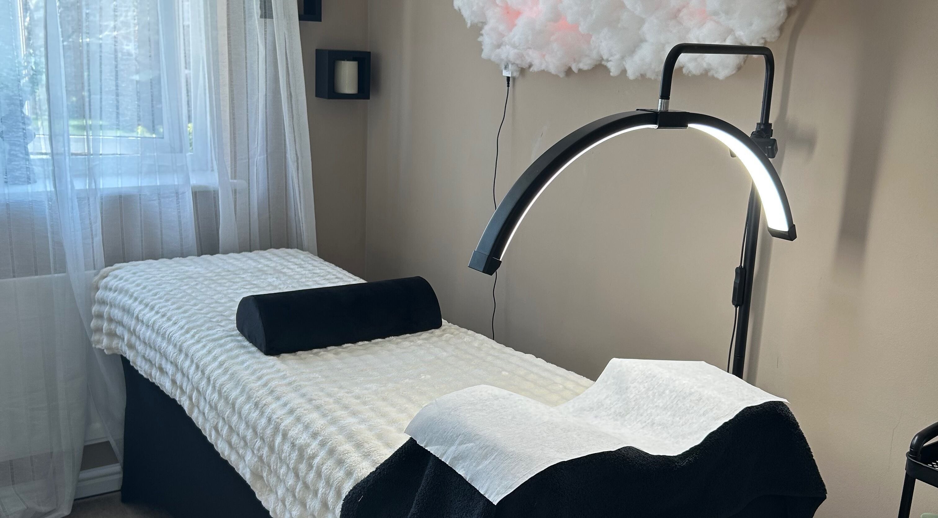 Tranquil treatment room at By Jade, Biggleswade, England, GB with therapy bed and modern lighting.