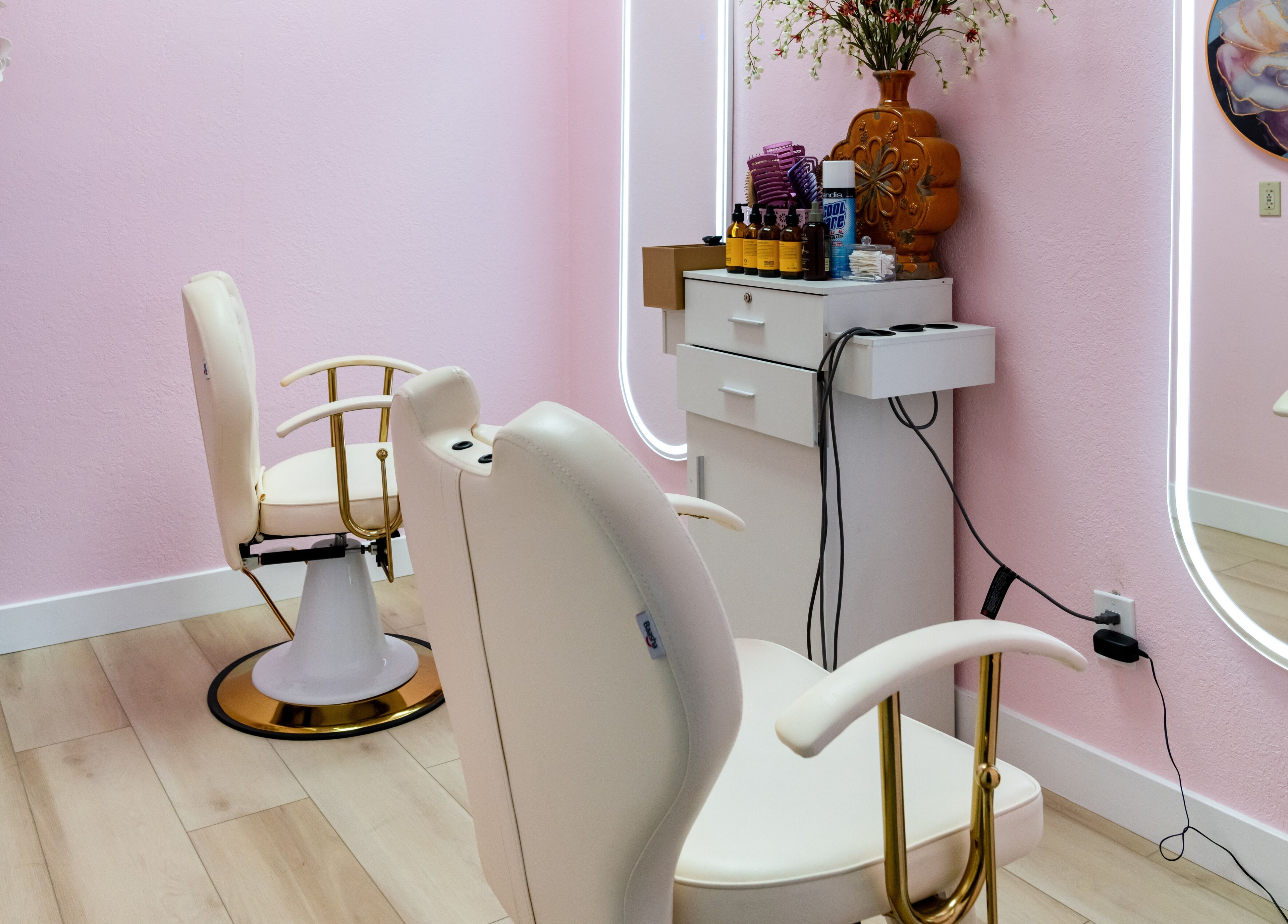 Elegant salon chairs at Jen Head Spa in San Jose, California, US, with pink walls and decorative elements.